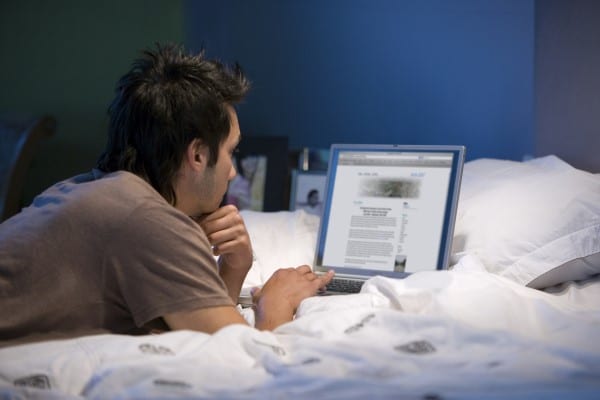 Asian man looking at laptop